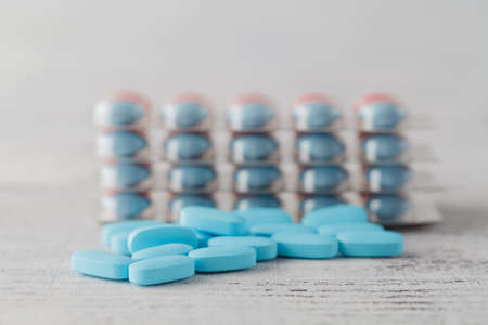 Pile of medical pills on wooden tableの写真素材