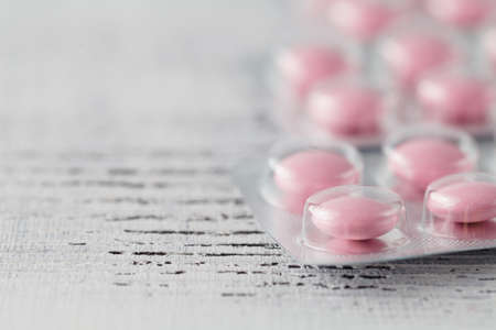 heap of pills on white wooden tableの写真素材