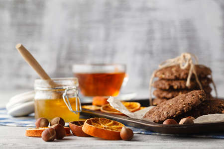 Homemade oat cookies with honey and cup of teaの写真素材