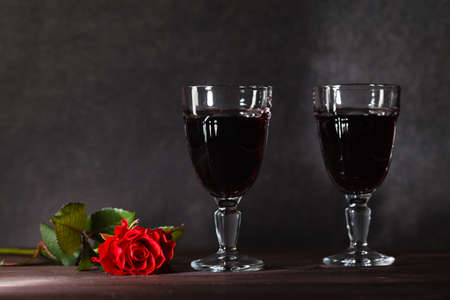 Two wine glass on dark table with roseの写真素材