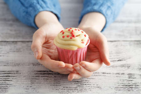 Young woman offer fresh muffin holding in handsの写真素材