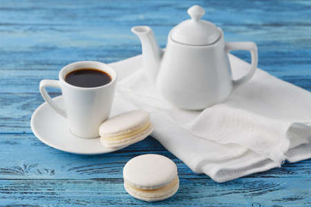 Breakfast concept. Coffee cup and white macaroon on napkinの写真素材