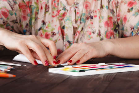 adult woman do origami boat from paper sheetの写真素材