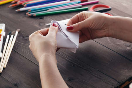 Woman do origami, bend paper sheet for do figureの写真素材