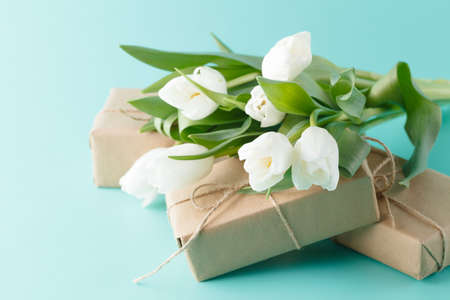 Present of spring flowers white tulips with giftsの写真素材
