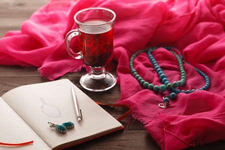 jewelry sketch in notepad on table with silk shawl and teaの写真素材