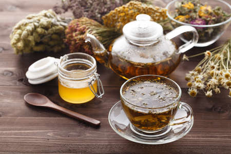 medicinal tea in glass cup with dried herb in bowlの写真素材