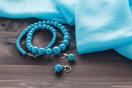 turquoise handmade bijouterie lay on table with silk shawlの写真素材