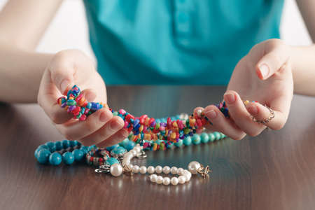 girl holds a pile of jewelry in handsの写真素材