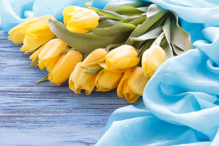 Fresh spring yellow flowers tulips lay on tableの写真素材