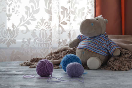 Piles of multi-colored colorful balls from wool on with small toy
