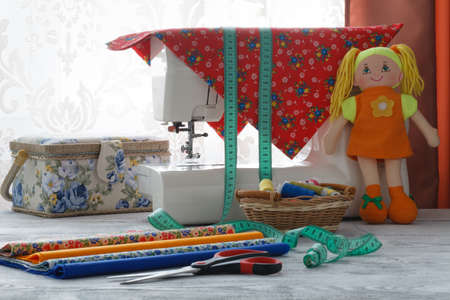 Sewing machine with many sewing utensils on a wooden table