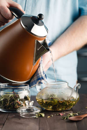 man pouring herbal tea in the glassの写真素材