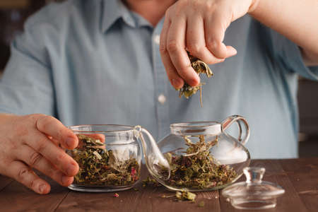 Man prepares herbal tea in kettleの写真素材