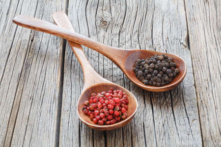 Colored pepper in a vintage wooden spoon on tableの写真素材