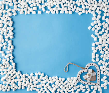 Top view picture of a lot of white sweeties marshmallows over blue table background.の写真素材