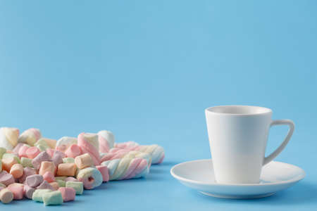 Twisted marshmallow on vibrant blue background with coffeeの写真素材