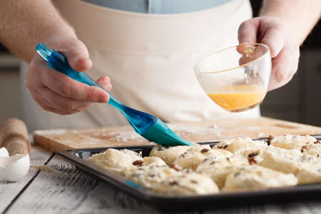 smearing raw buns with brush in yolk, preparation processの写真素材