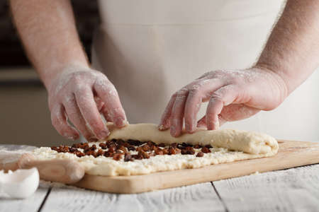 Close-up the hand of a baker kneading and shaping doughの写真素材