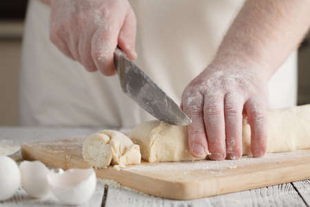 chef cooking (preparing cottage cheese pancakes) on a wooden boardの写真素材