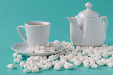 Pastel marshmallow in a white cup on a blue background. Sweet unhealthy food. Minimalism styleの写真素材