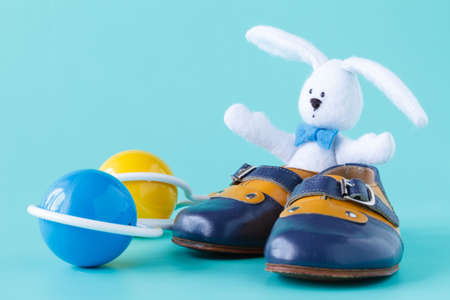 Classic rattle toy with booties on aquamarine backgroundの写真素材