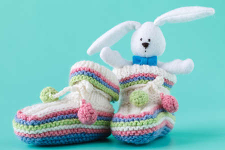 Knitted baby booties with toyの写真素材