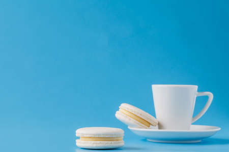 Macaroons with coffee cup on the blue paper backgroundの写真素材