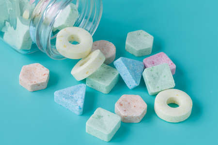Candy in glass jar on blue background. Close up