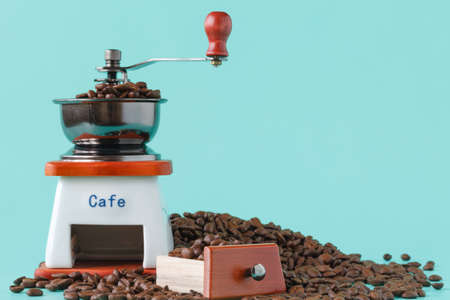 Traditional wooden coffee mill grinder over aquamarine backgroundの写真素材