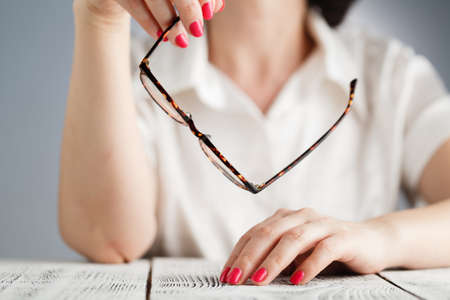 Beautiful casual woman holding glassesの写真素材