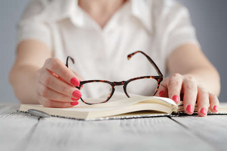 Education and business concept - businesswoman wearing eyeglasses in officeの写真素材