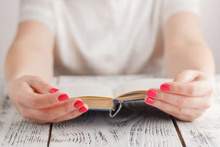 woman at work holding on to a book flipping through pagesの写真素材