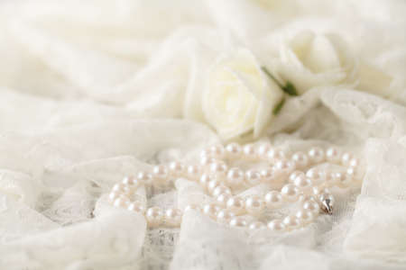 Pearl necklace on lace clothes background.の写真素材