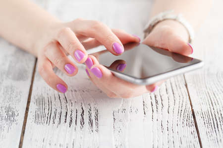 A business woman's hands holding and touching smart phoneの写真素材