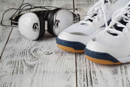 Sport shoes with headphones on wooden backgroundの写真素材