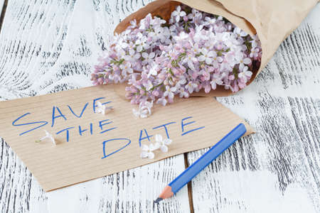 Lilac flowers with empty tag on a old wooden background