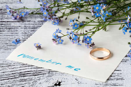 page of a notebook, there is a bouquet of forget-me-nots on it and words remember meの写真素材