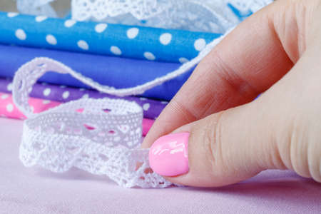 woman sewing a natural beige linen tablecloth lace ribbonの写真素材