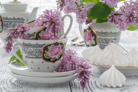 Cup of tea with lilac flowers on white background. Summer tea time concept. Breakfast tea cup served with flowers.の写真素材