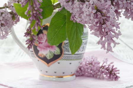 Vase with a bouquet of purple lilac spring flowers on vintage textured backgroundの写真素材