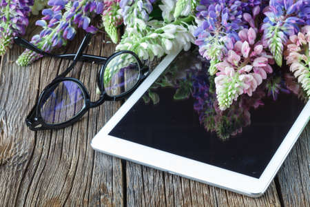 glasses on tablet  and flowersの写真素材