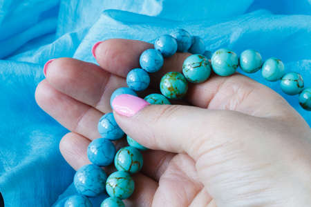 Strings of turquoise beads on blue silkの写真素材