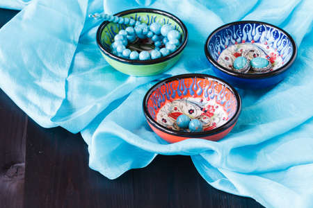 turquoise earrings on bowl. Fashion backgroundの写真素材