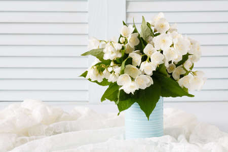 Fresh jasmine flowers in a vase on wooden backgroundの写真素材