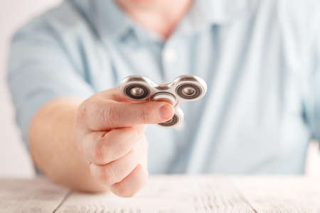 Male hand holding popular fidget spinner toyの写真素材
