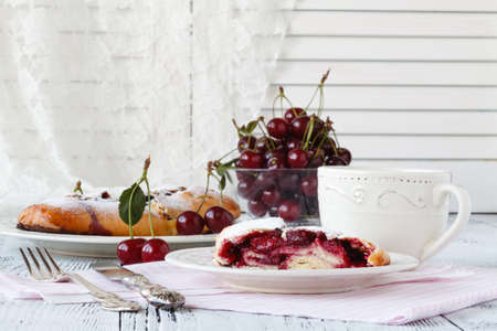 Slice of cherry pie with ice cream on a white textile backgroundの写真素材