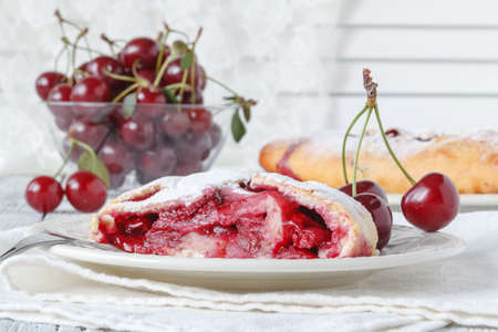 Tasty cherry pie on plates, placed on wooden tableの写真素材