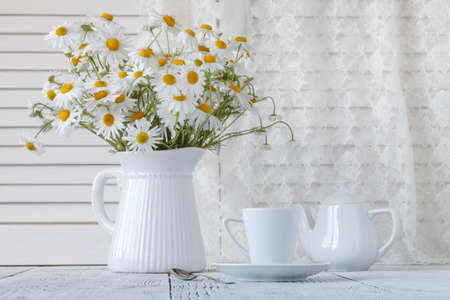 Bouquet of chamomile in a vase on the old boards.の写真素材