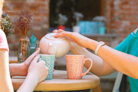 Female pouring tea in morning cafeの写真素材